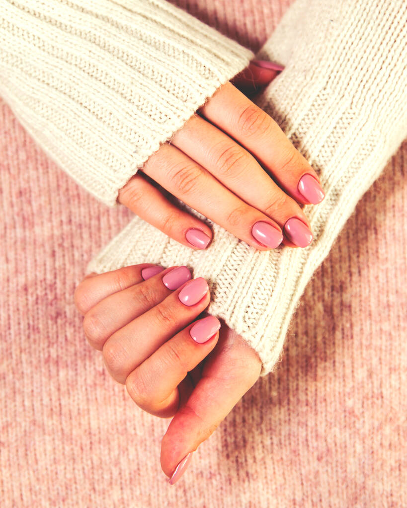 Girl with manicure in a warm sweater. - 写真・画像
