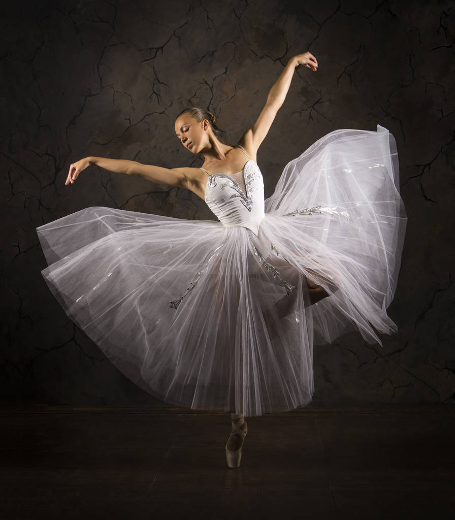 Струнка дівчина в білому корсеті підручник танцює балет
. - Фото, зображення
