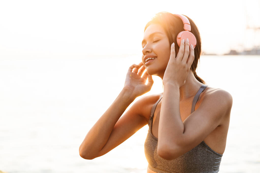 Image of happy asian woman listening to music with headphones by - Photo, Image