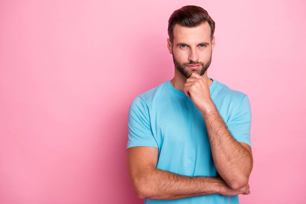 Photo de sérieux homme confiant avec soies touchant son menton barbu vous regardant pensivement isolé rose fond de couleur pastel
 - Photo, image