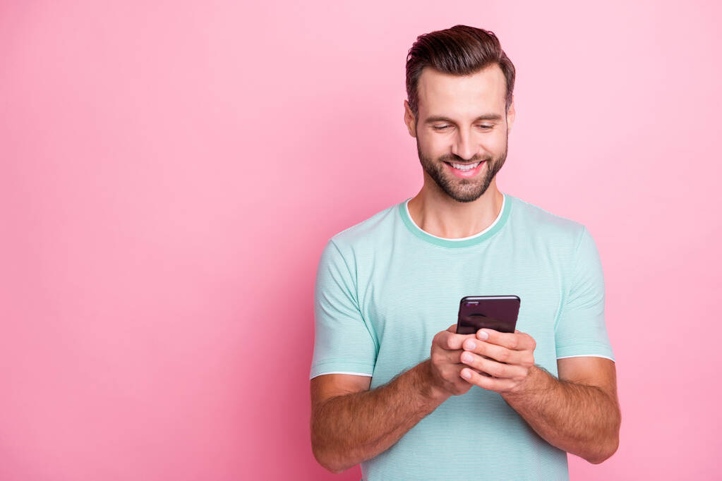 Portrét pozitivní veselý muž pomocí svého smartphonu čtení sociálních médií zprávy nosit ležérní styl oblečení izolované pastelové barvy pozadí - Fotografie, Obrázek