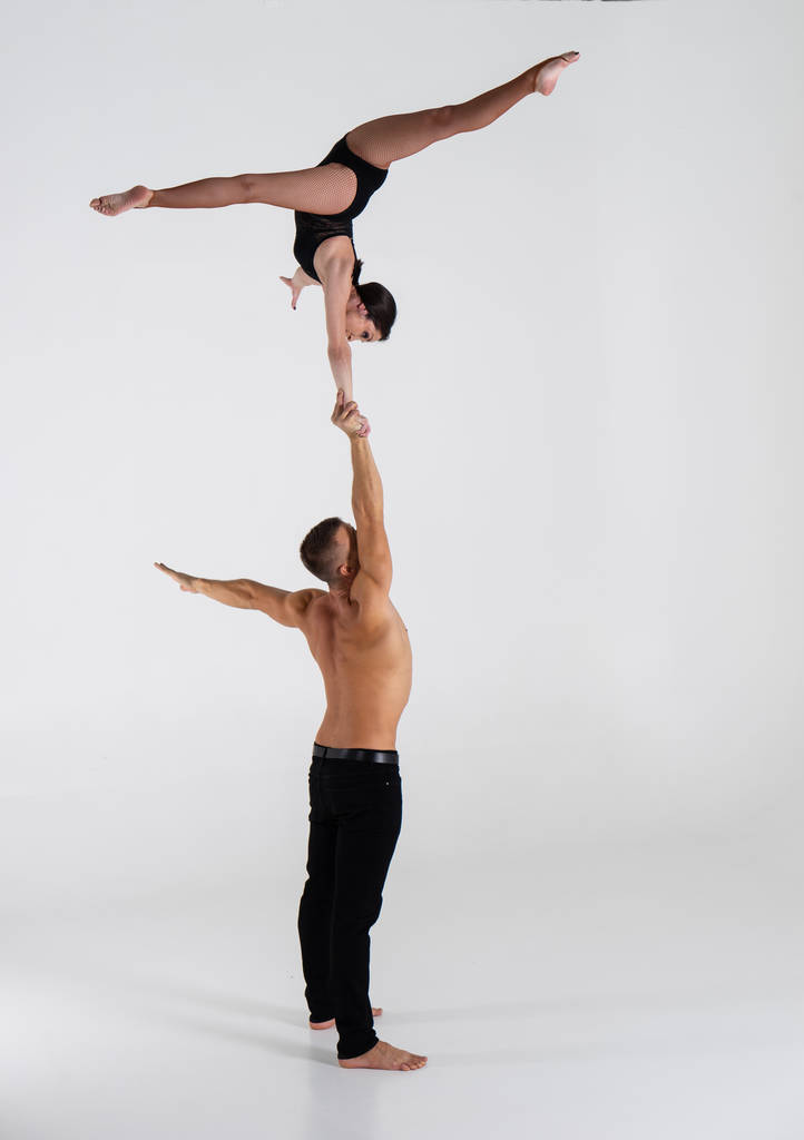 Akrobaten-Duo zeigt Hand-in-Hand-Trick, isoliert auf weiß - Foto, Bild