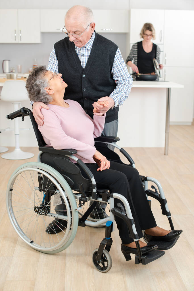 starší muž dotýkající se ženy na invalidním vozíku - Fotografie, Obrázek