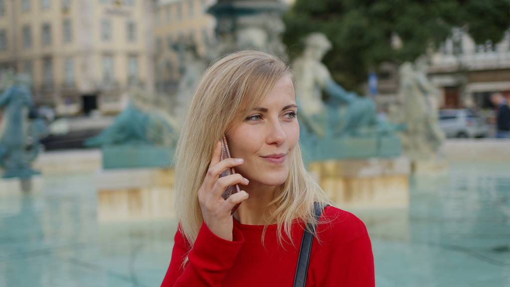 Mujer joven recibe una llamada telefónica en la ciudad de Lisboa
 - Foto, Imagen