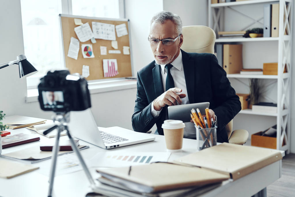Senior-Mann im eleganten Business-Anzug mit digitalem Tablet beim Drehen von Social-Media-Videos - Foto, Bild