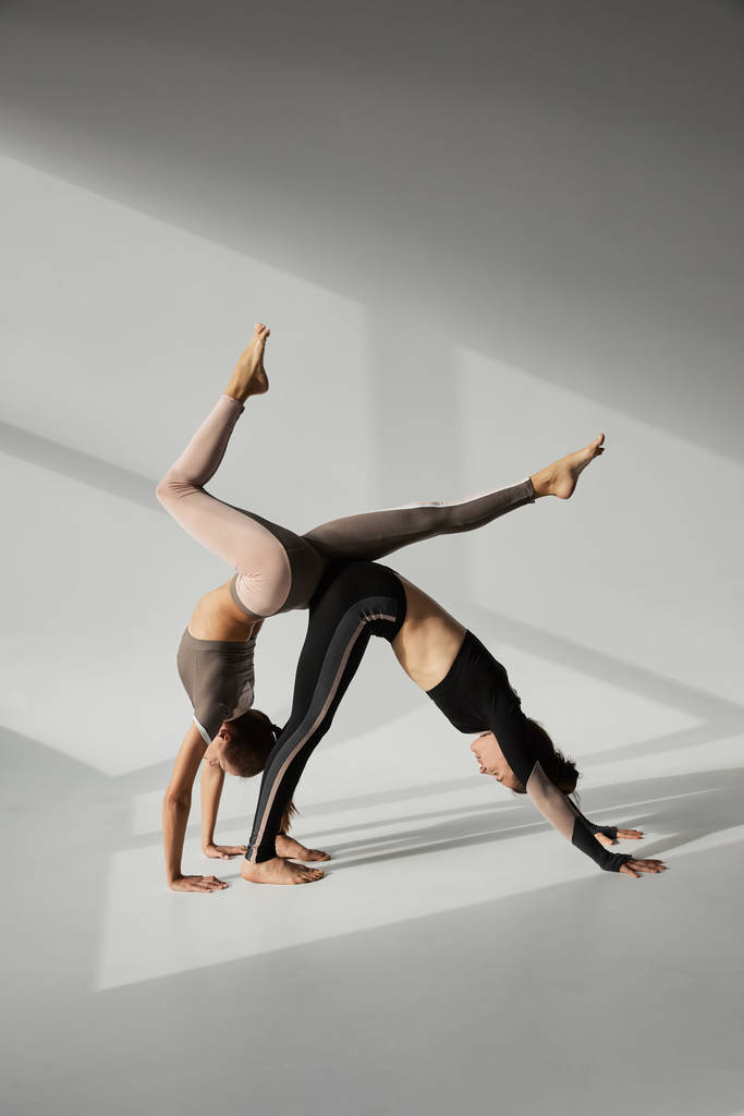 Две женщины, практикующие акройогу в студии Сууни
  - Фото, изображение