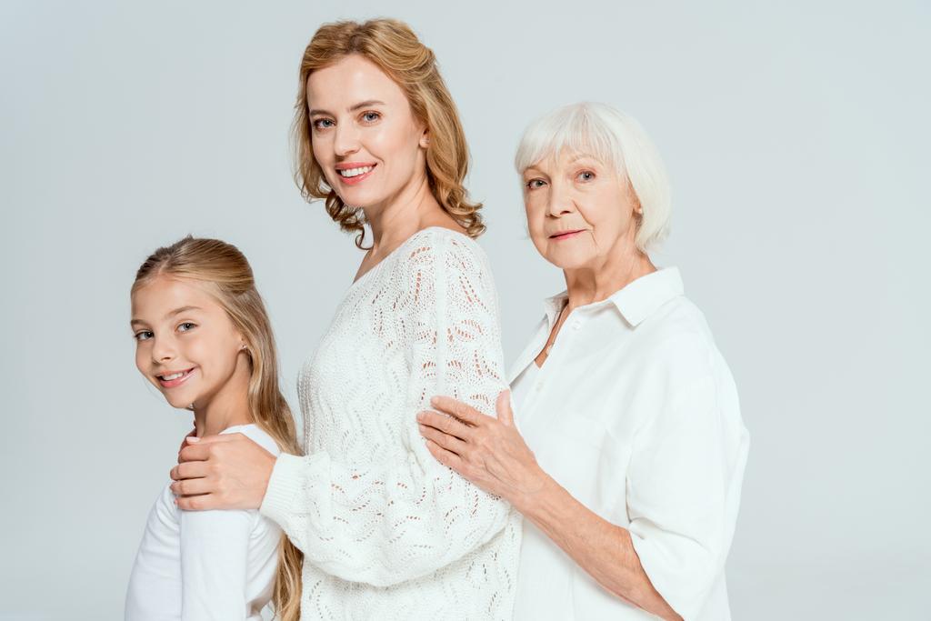 sourire petite-fille, mère et grand-mère câlins isolés sur gris
  - Photo, image