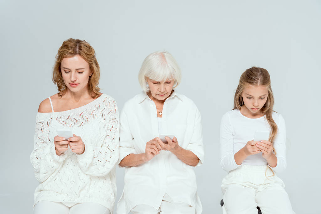 unoka, anya és nagymama használja okostelefonok elszigetelt szürke  - Fotó, kép