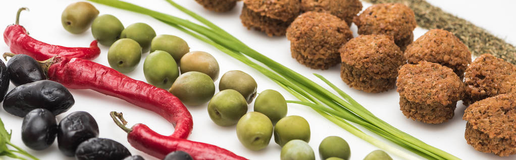 vista ravvicinata di prezzemolo, olive, peperoncino, cipolla verde, erba e falafel su sfondo bianco, colpo panoramico
 - Foto, immagini