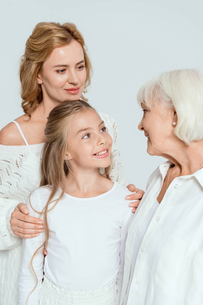 nieta sonriente, madre y abuela mirándose aisladas en gris
  - Foto, imagen