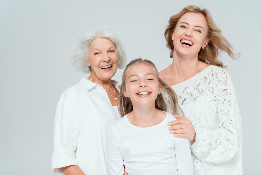 petite-fille, mère et grand-mère souriantes regardant la caméra isolée sur gris
  - Photo, image