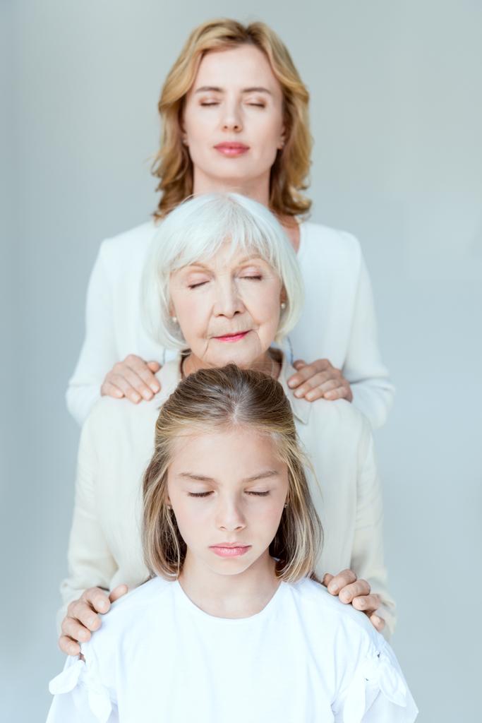 nipote, nonna e madre con gli occhi chiusi abbracciati isolati su grigio
  - Foto, immagini