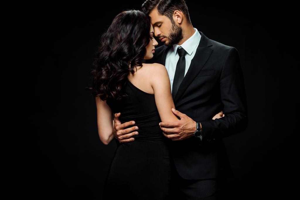 привлекательная женщина в платье обнимая бородатый мужчина изолирован на черный
  - Фото, изображение
