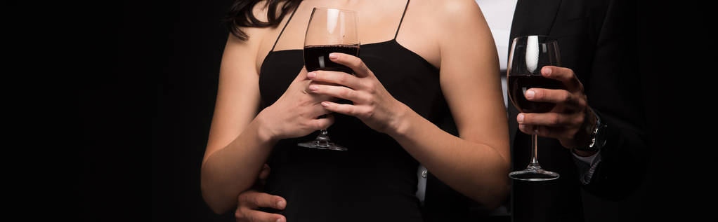 男性と女性のパノラマ撮影黒ワインで隔離された赤ワインとメガネを保持  - 写真・画像
