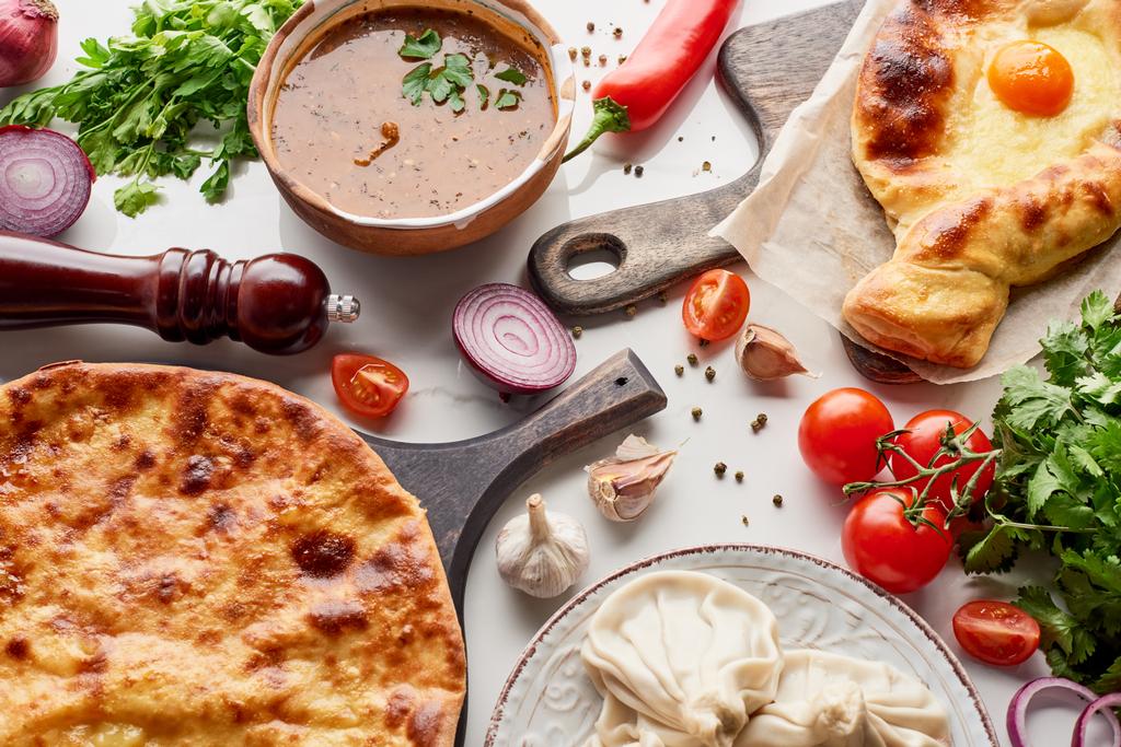 Adjarian ve imereti khachapuri, kharcho çorbası ve mermer dokuda sebze ve baharatlar. - Fotoğraf, Görsel