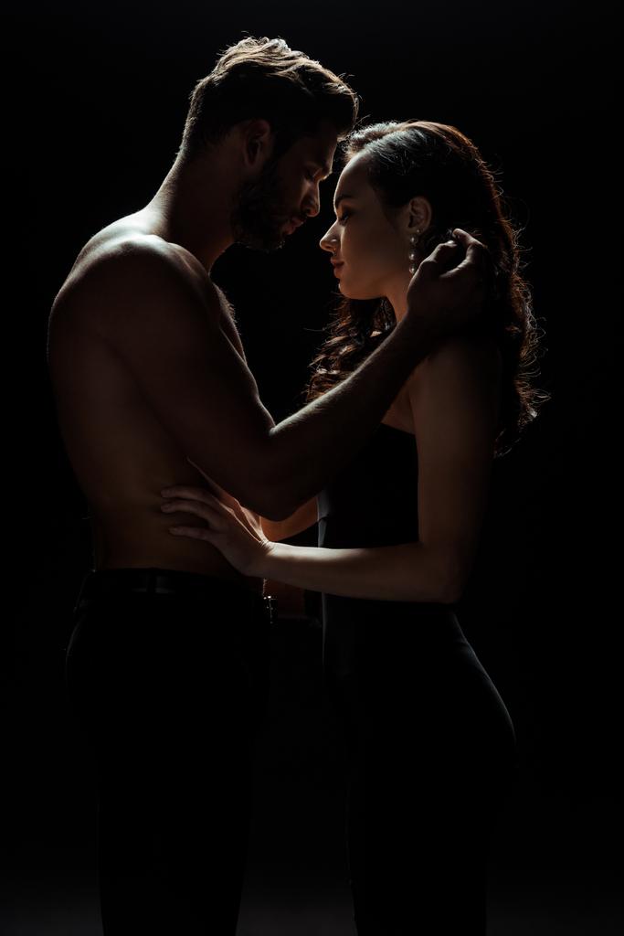 side view of shirtless man touching attractive woman isolated on black  - Photo, Image