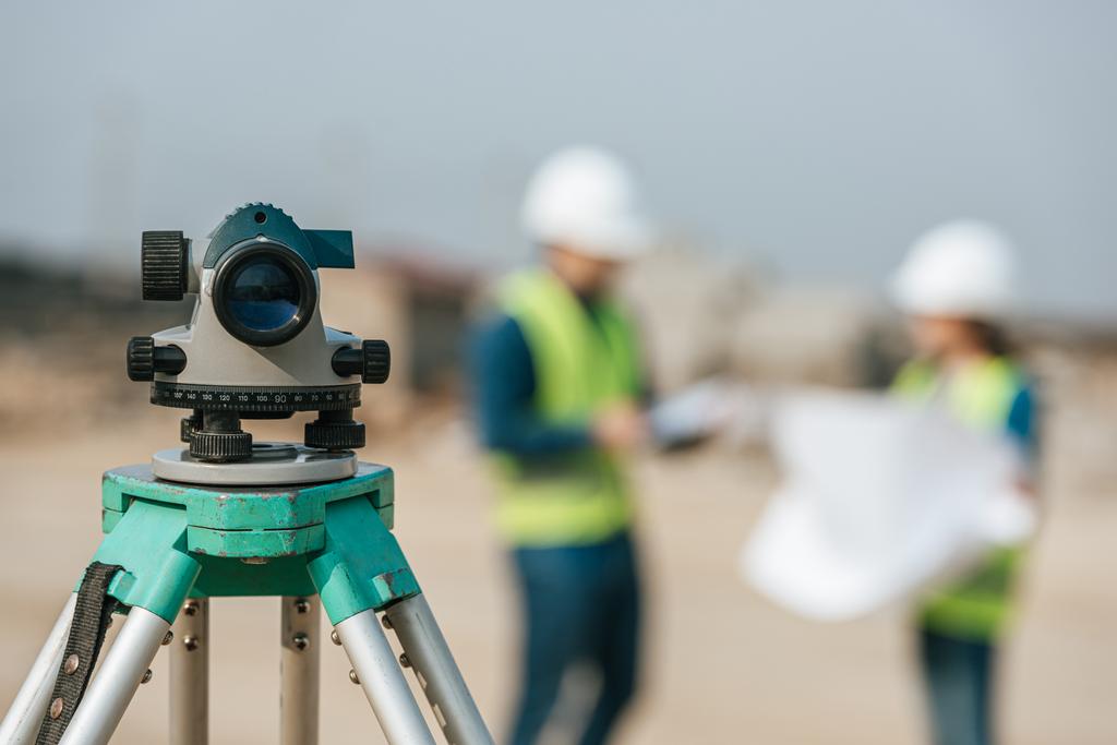 Selective focus of digital level and surveyors with blueprint at background - Photo, Image