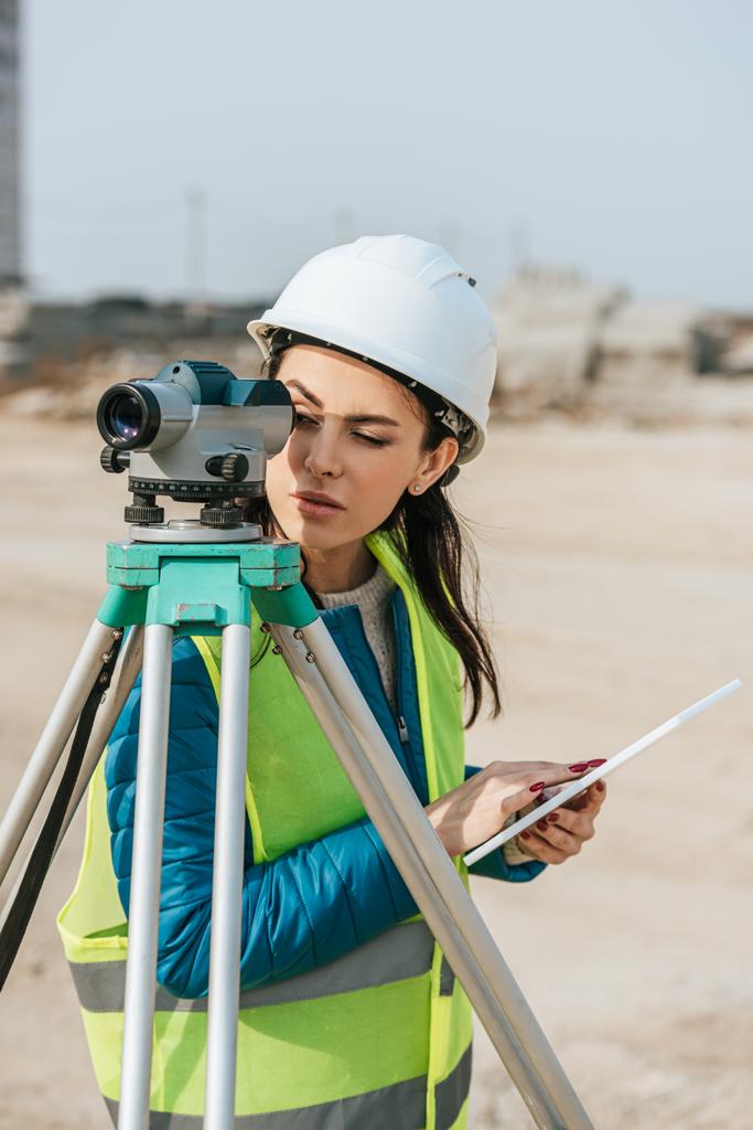Surveyor with digital tablet looking through measuring level - Photo, Image