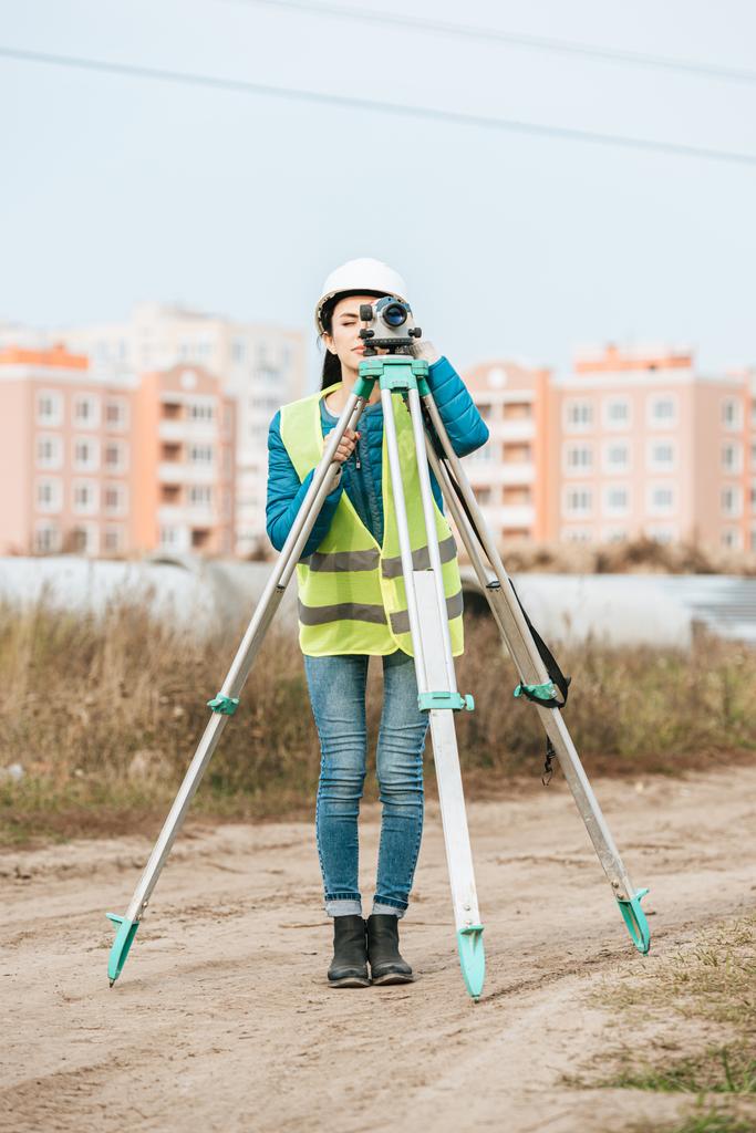デジタルレベルの土地を測定する女性測量士 - 写真・画像