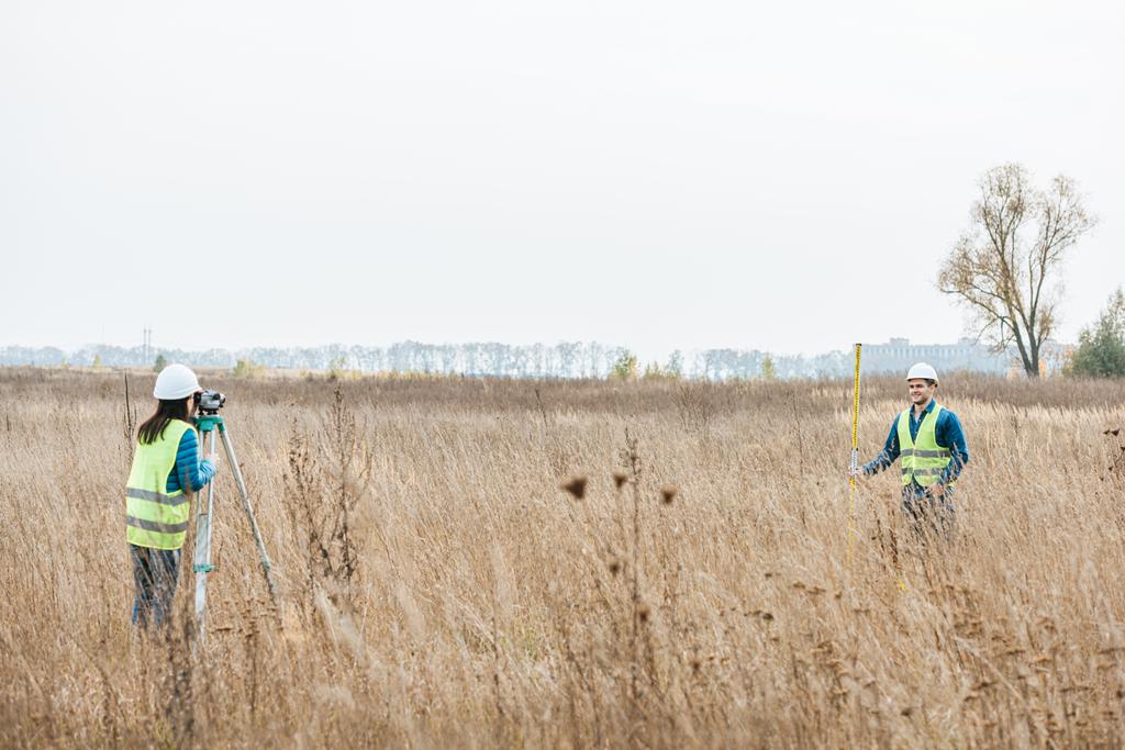 Průzkumníci měří pozemky s digitální úrovní a pravítkem v terénu - Fotografie, Obrázek