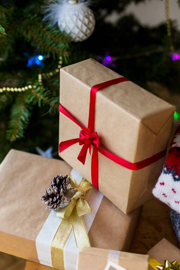 Κουτιά δώρου με κορδέλες με χριστουγεννιάτικο δέντρο στο φόντο - Φωτογραφία, εικόνα