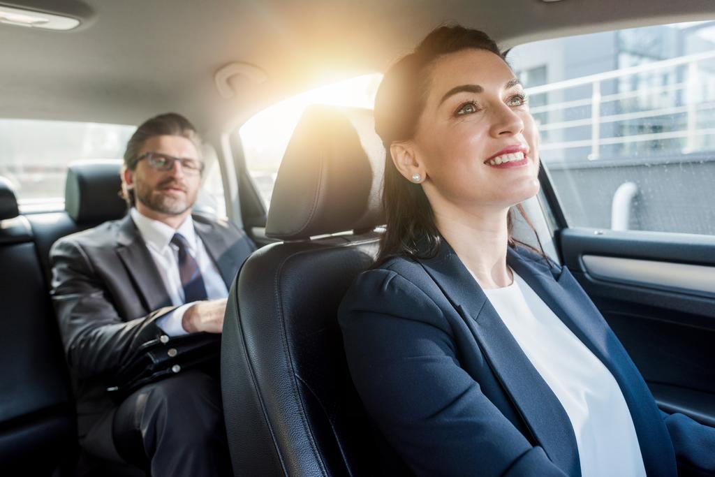 enfoque selectivo de mujer atractiva sentada en coche con diplomático barbudo
  - Foto, imagen