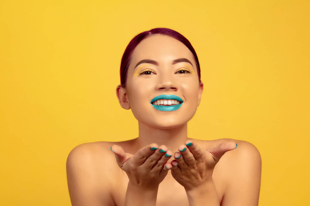 Πορτρέτο της όμορφης νεαρής γυναίκας με φωτεινό μακιγιάζ απομονώνονται σε κίτρινο φόντο στούντιο - Φωτογραφία, εικόνα