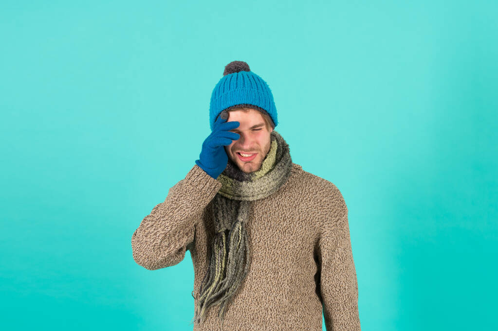 Мені шкода. Чоловік вродливий незахищений хлопець носить зимові аксесуари на синьому фоні. Зимовий сезон. Хіпстер в'язав зимовий капелюх шарф і рукавички. Концепція покупок. Емоційний вираз. Забули
 - Фото, зображення
