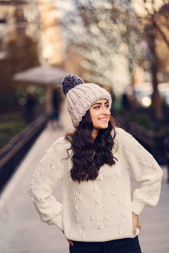 Roztomilá brunetka v bílém svetru ve městě - Fotografie, Obrázek