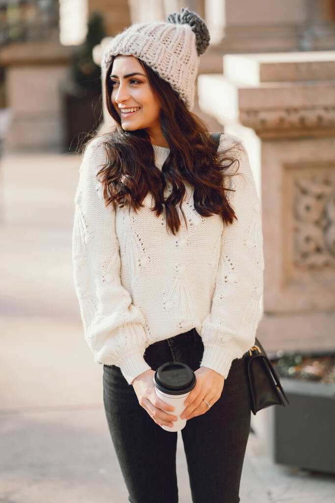 Linda morena en un suéter blanco en una ciudad - Foto, Imagen