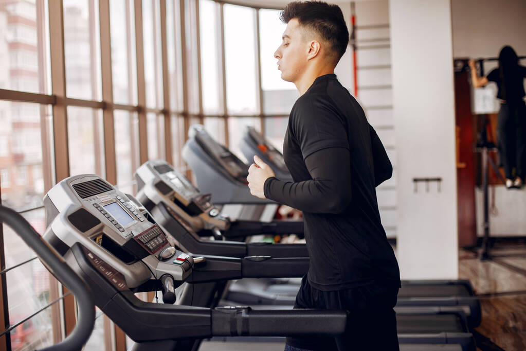 Ein schöner Mann ist in einem Fitnessstudio beschäftigt - Foto, Bild