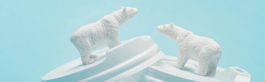 Panoramaaufnahme von Spielzeug-Eisbären auf Plastikkaffeedeckeln auf blauem Hintergrund, Tierschutzkonzept - Foto, Bild
