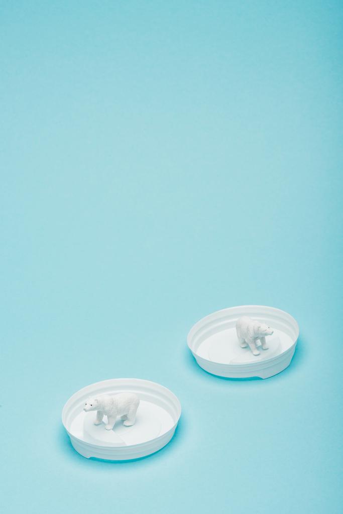 白いおもちゃのホッキョクグマプラスチックコーヒー蓋の上に青の背景、動物福祉の概念 - 写真・画像