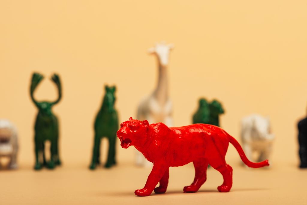 黄色の背景に色のおもちゃの動物と赤虎の選択的な焦点,動物の概念の絶滅 - 写真・画像