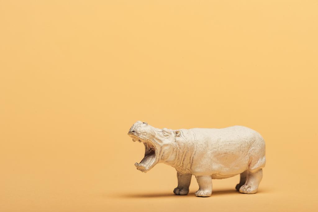 White toy hippopotamus on yellow background, animal welfare concept - Photo, Image