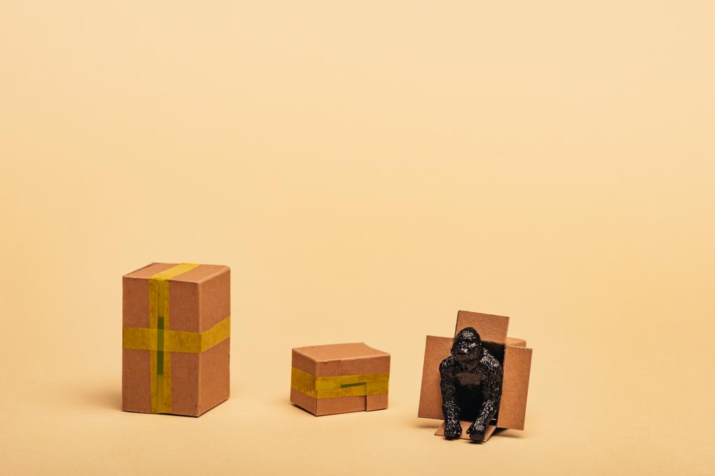 Zabawka goryl w kartonowym pojemniku z pudełkami na żółtym tle, koncepcja dobrostanu zwierząt - Zdjęcie, obraz