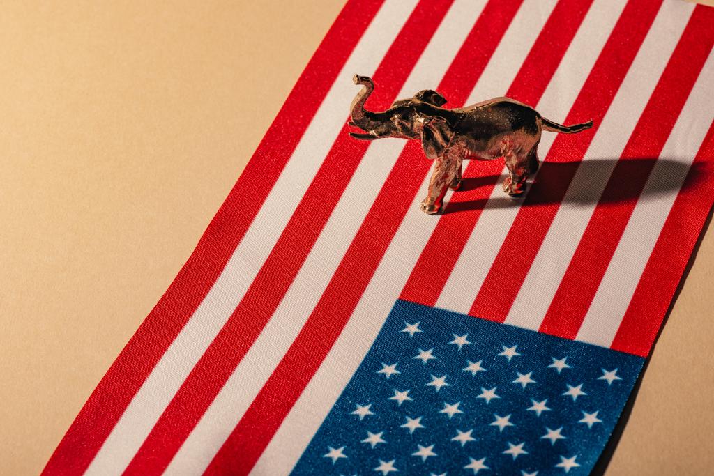 Éléphant jouet doré avec ombre sur drapeau américain, concept de bien-être animal
 - Photo, image