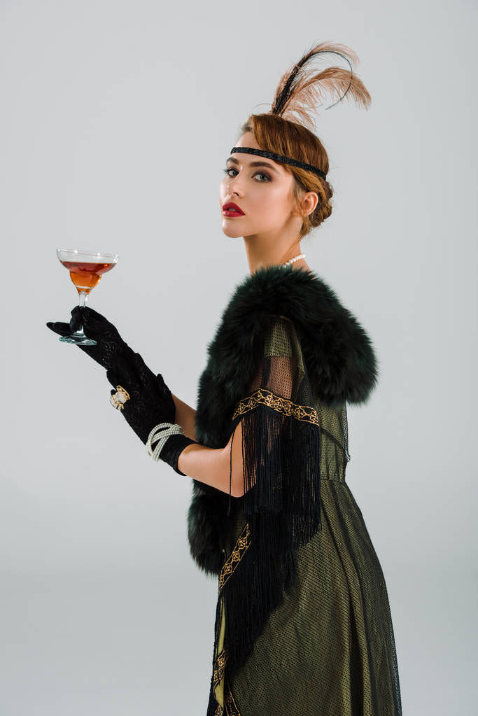 aristokratická žena držící alkohol nápoj izolovaný na šedi  - Fotografie, Obrázek