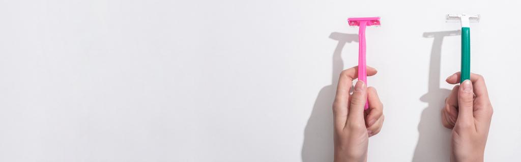 vista recortada de la mujer sosteniendo navajas de afeitar sobre fondo blanco, plano panorámico
 - Foto, Imagen