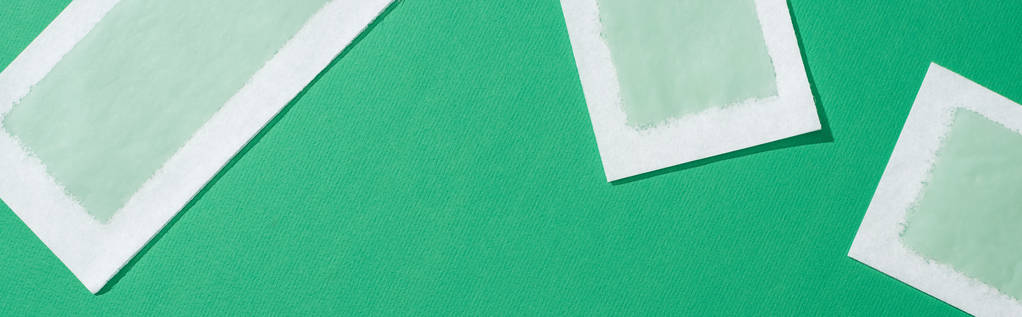 vista superior de las rayas de cera depilación sobre fondo verde, plano panorámico
 - Foto, imagen