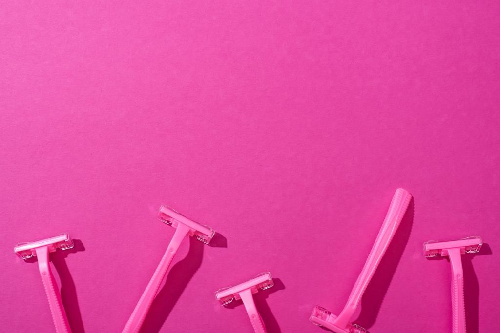 вид зверху на жіночі одноразові бритви на рожевому фоні
 - Фото, зображення