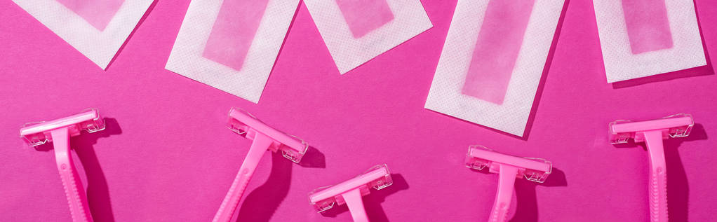 top view of disposable razors and wax depilation stripes on pink background, panoramic shot - Photo, Image