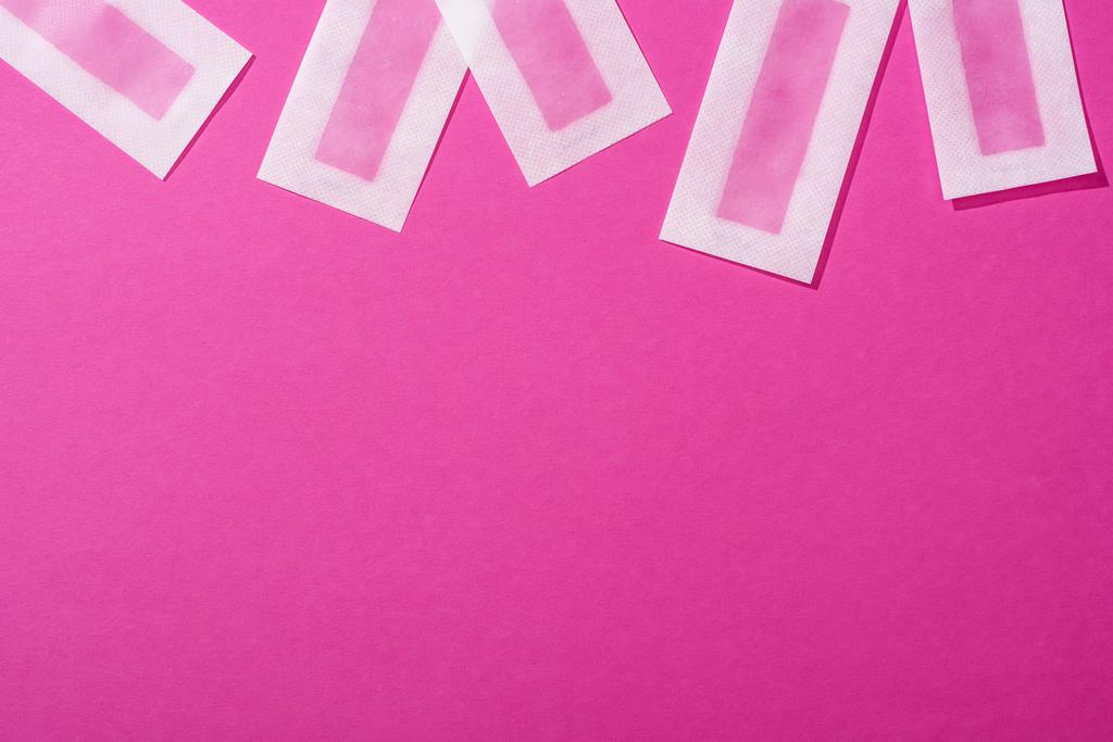widok górny pasków depilacyjnych wosku na różowym tle - Zdjęcie, obraz