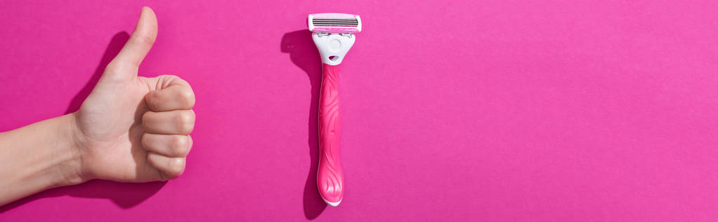 vista recortada de la mujer que muestra el pulgar hacia arriba cerca de la navaja de afeitar sobre fondo rosa, plano panorámico
 - Foto, imagen