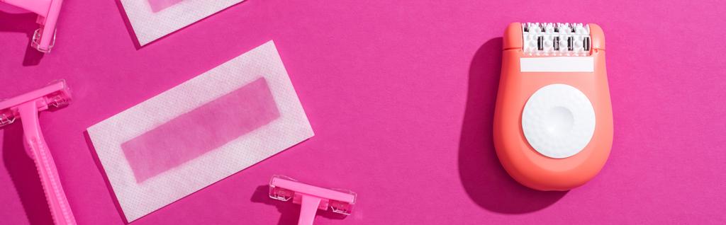 使い捨てのカミソリとエピレーターとワックスの剥離縞がピンクの背景でパノラマ撮影されました - 写真・画像