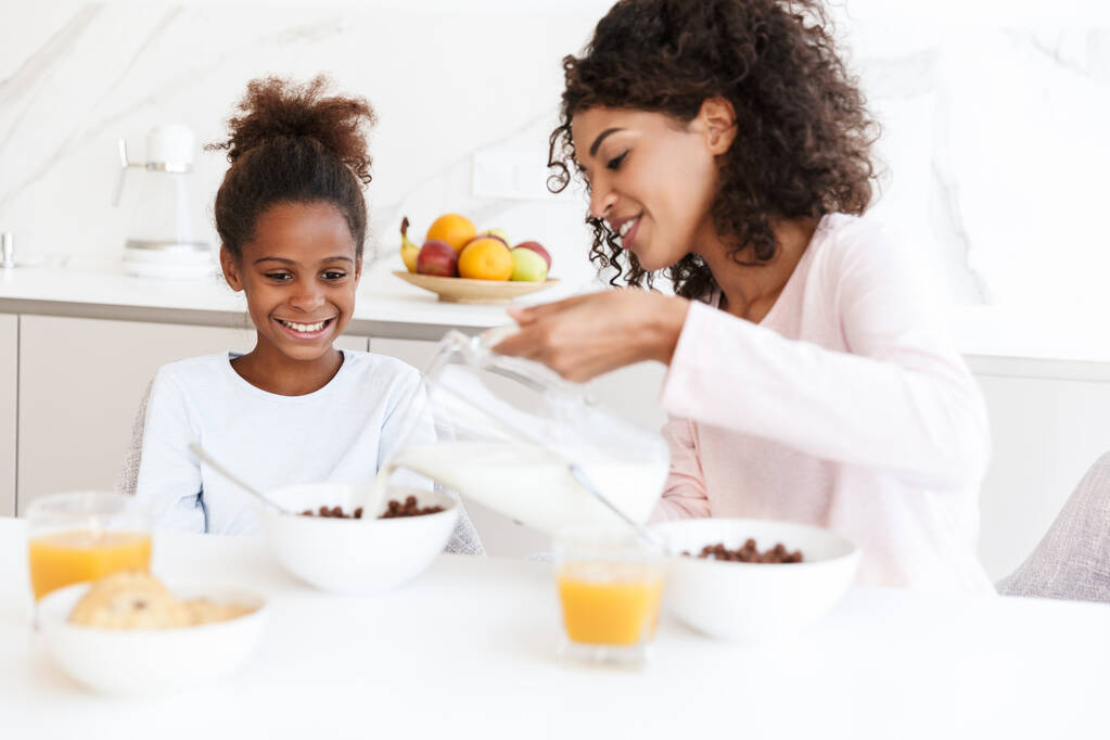 Obraz amerykańskiej kobiety karmiącej córkę podczas śniadania - Zdjęcie, obraz