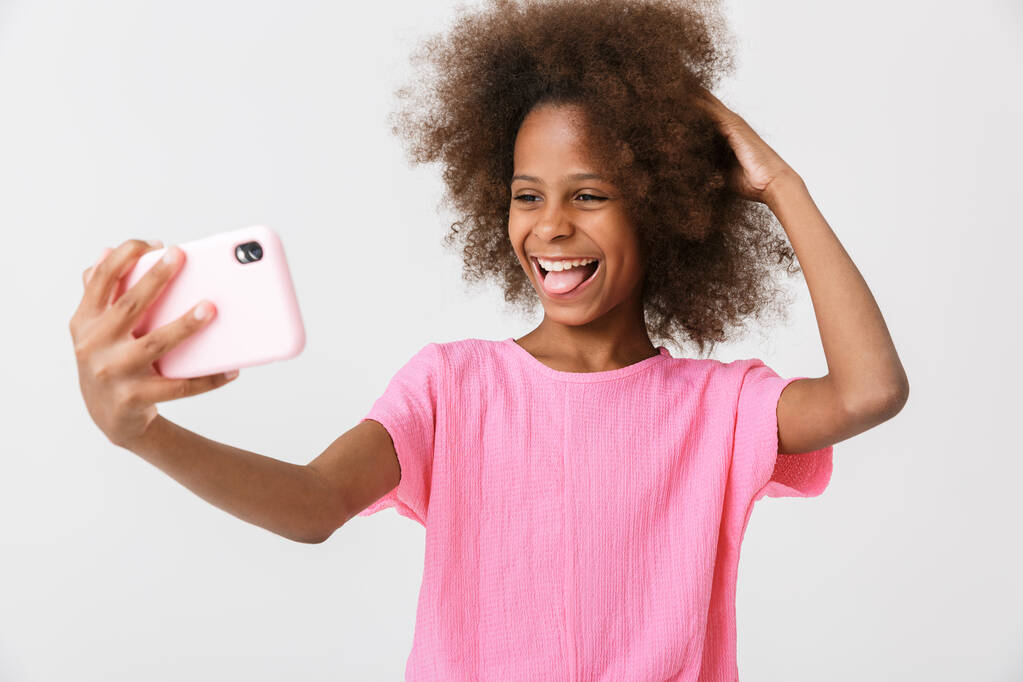 Веселая маленькая африканская девочка в розовой блузке стоя
 - Фото, изображение