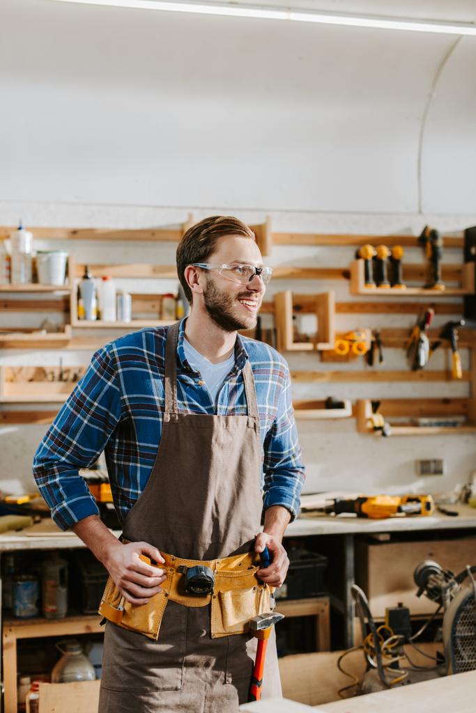 счастливый бородатый плотник в очках касаясь инструмента пояса
  - Фото, изображение