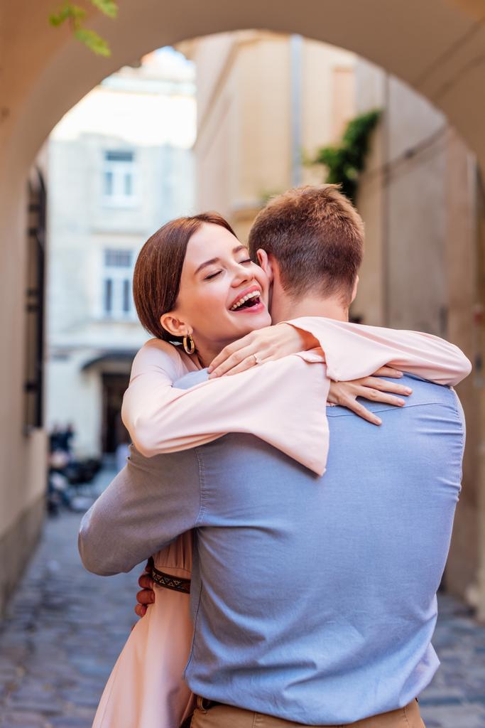 felice giovane donna abbracciare fidanzato sulla strada con gli occhi chiusi
 - Foto, immagini