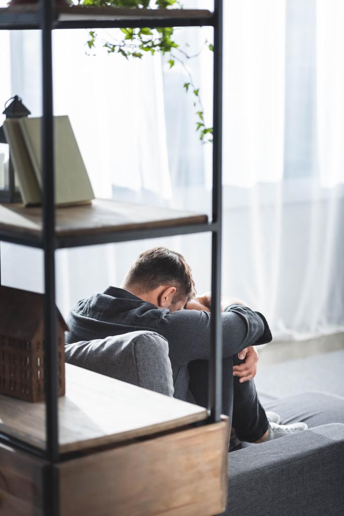 visszapillantás férfi pánikroham sír és ölelés lábak lakásban  - Fotó, kép